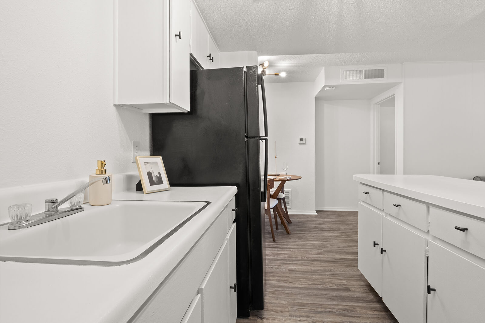 an apartment kitchen with a sink in view